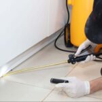 Pest control technician applying indoor treatment illustrating why is pest control important for home protection.