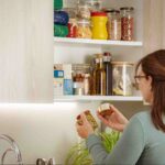 Homeowner organizing pantry containers as part of a pest control checklist for kitchen areas to prevent ants and pantry pests.